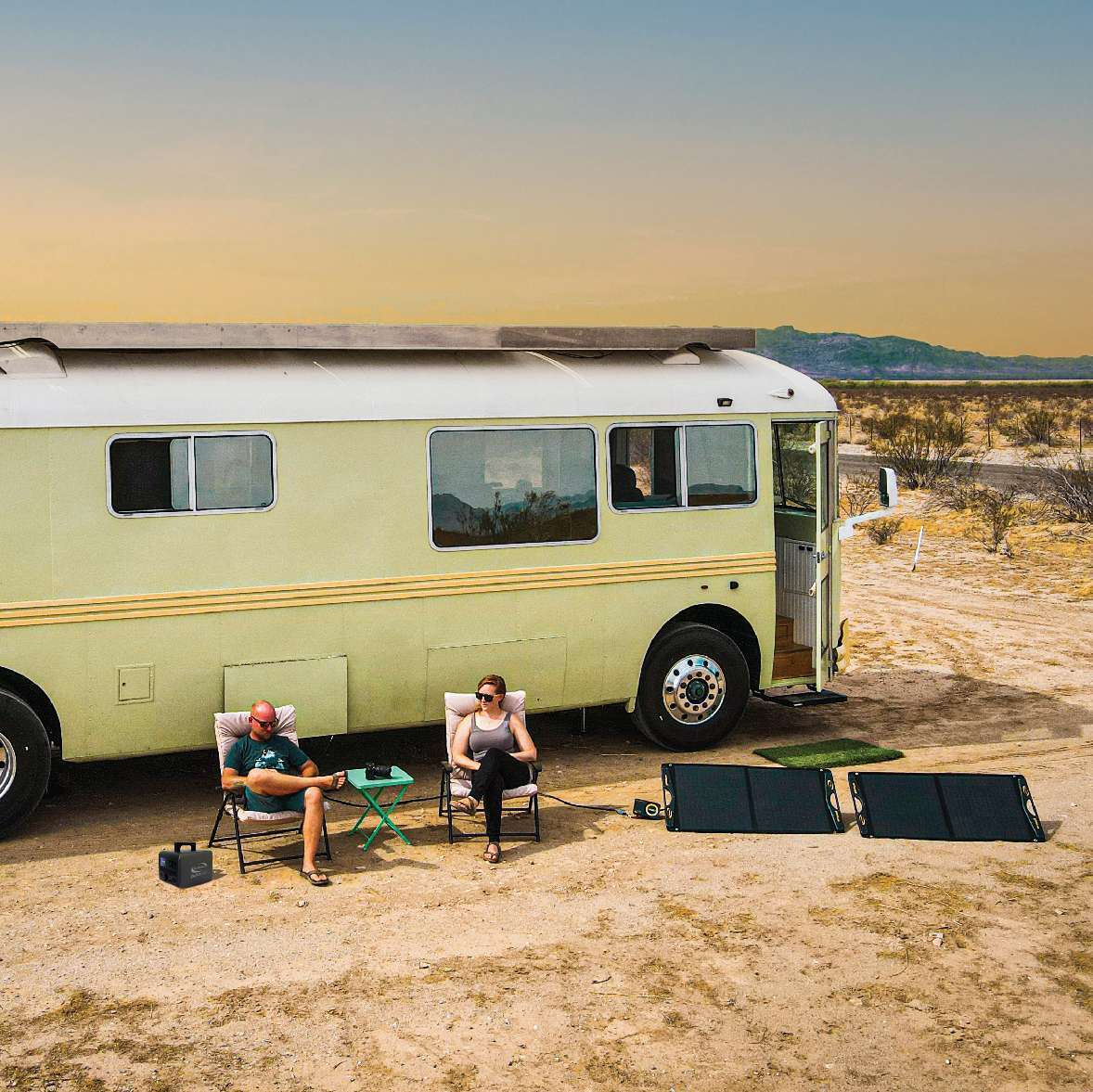 Vintage motorhome with portable solar panels set up at a desert camp