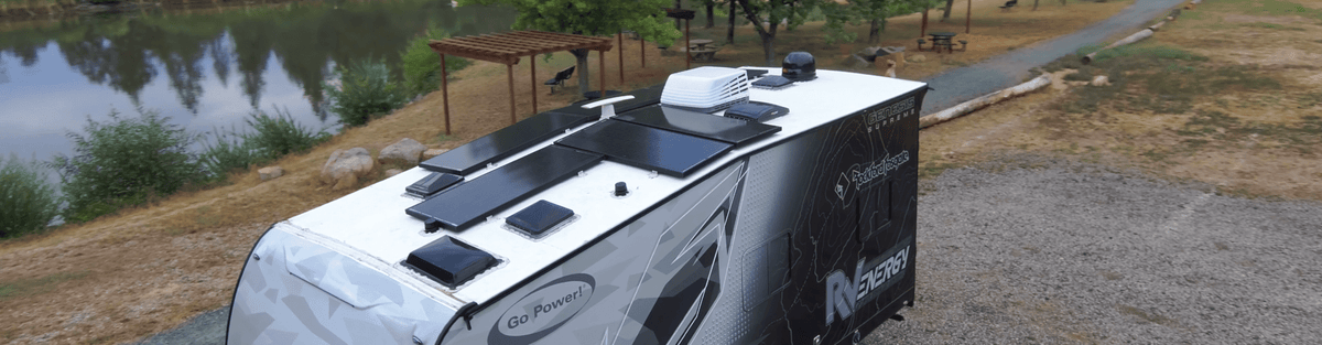 Solar panel on the roof of a travel trailer parked by a lake